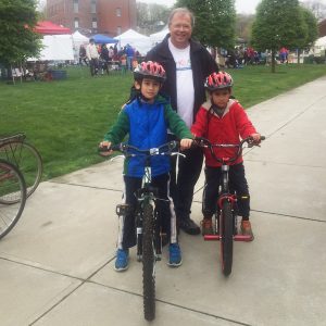 Attorney David White with children sitting on bicycles, wearing bicycle helmets