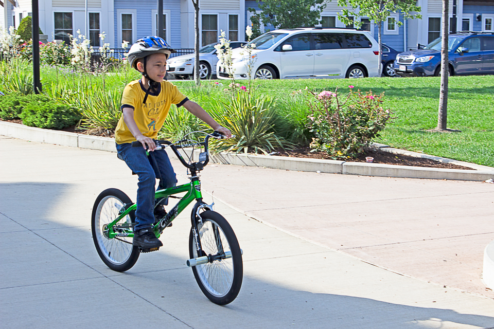 A child riding a bicycle wearing a bicycle helmet.