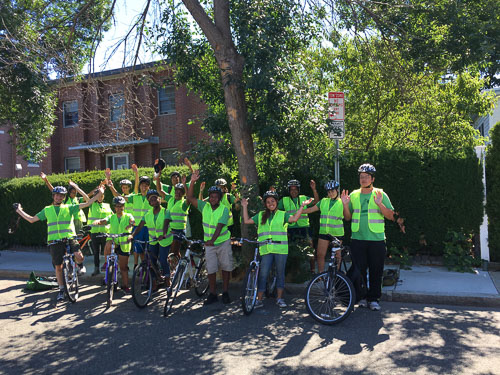 Students wearing bicycle helmets and neon vests in Somerville, Massachusetts.