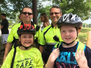 Quincy police officers and kids wearing bike helmets