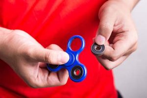 Fidget spinner missing a piece in boy's hands