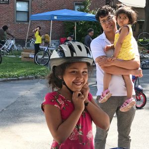 child in Arlington wearing a bike helmet donated by Breakstone, White & Gluck's Project KidSafe campaign