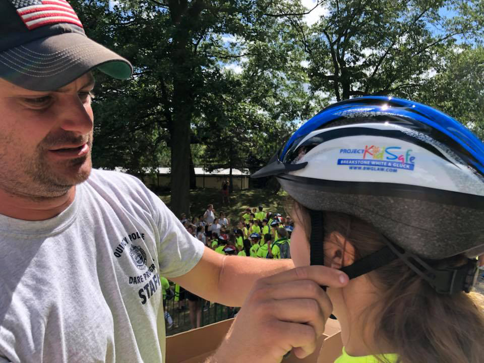 Quincy police officer fits a helmet