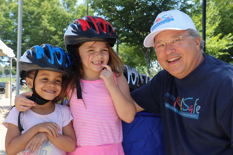 Attorney David W. White fitting bicycle helmets for kids at the Tierney Learning Center in South Boston.