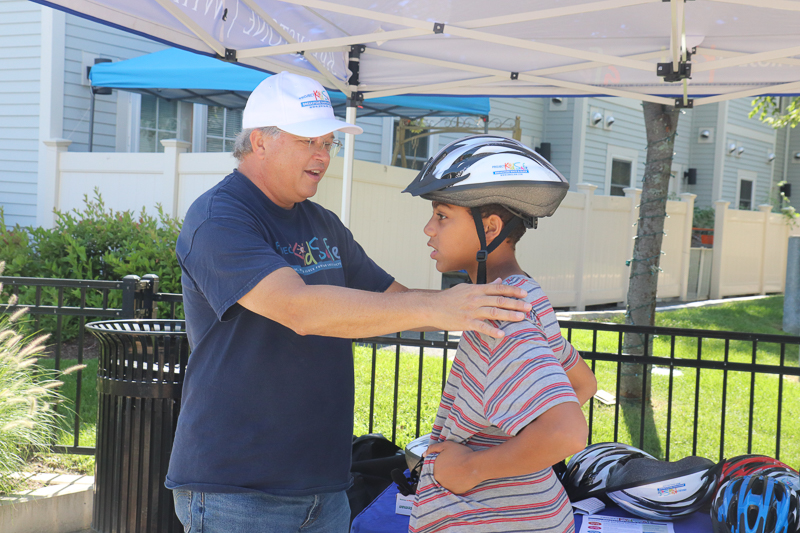 Attorney David W. White fits a helmet for a teenager at the Tierney Learning Center.
