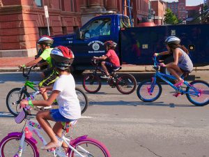 Kids riding bikes wearing Project KidSafe bike helmets in Lawrence, Massachusetts