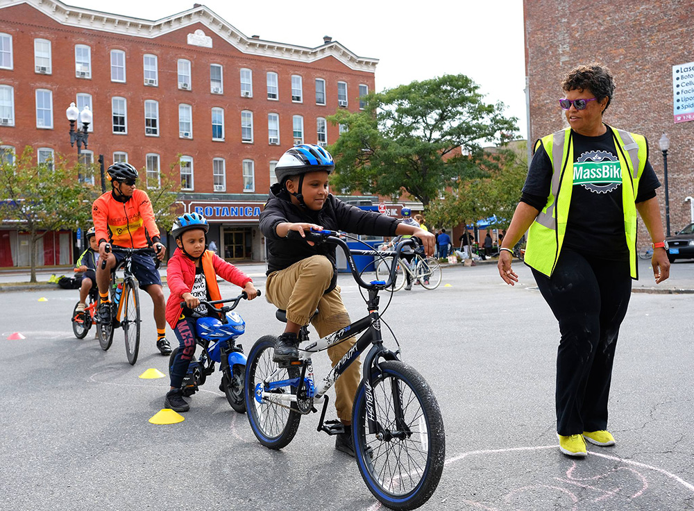 Children wearing Project KidSafe bicycle helmets at the Lawrence Ciclovia this summer. Breakstone, White & Gluck, a Boston personal injury law firm, donated the helmets as part of its Project KidSafe campaign.