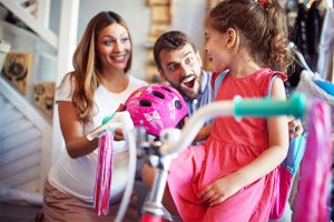 Child receiving a new bicycle and new bicycle helmet.