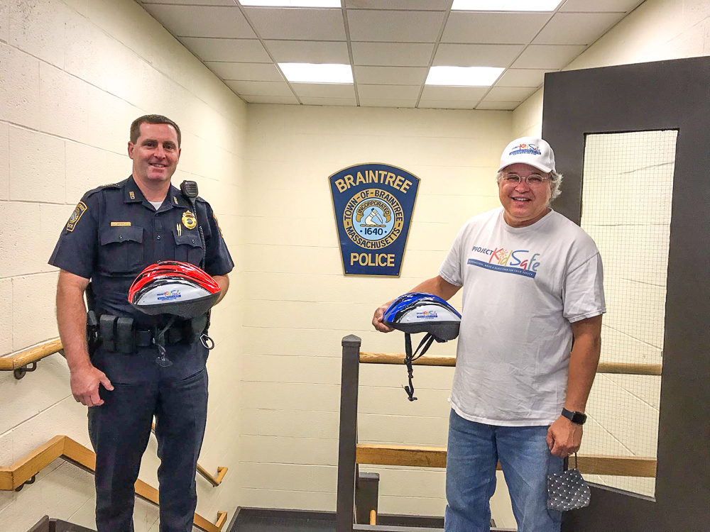 Boston lawyers of Breakstone, White & Gluck give Braintree Police free bike helmets for children.