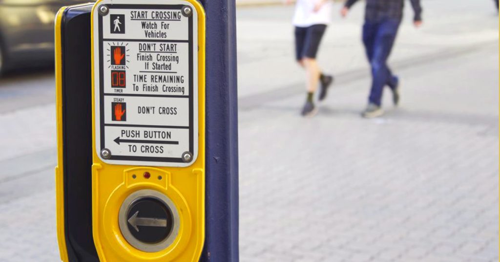 Walk signal reduces the risk of pedestrian accidents on a Boston street.