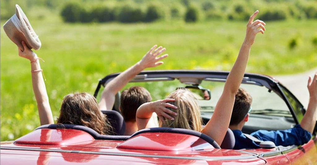 Teens driving away in convertible