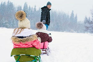 Parent sledding with children in Massachusetts