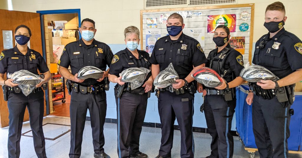 Framingham Police get ready to fit bicycle helmets at Fuller Middle School in June, 2021.