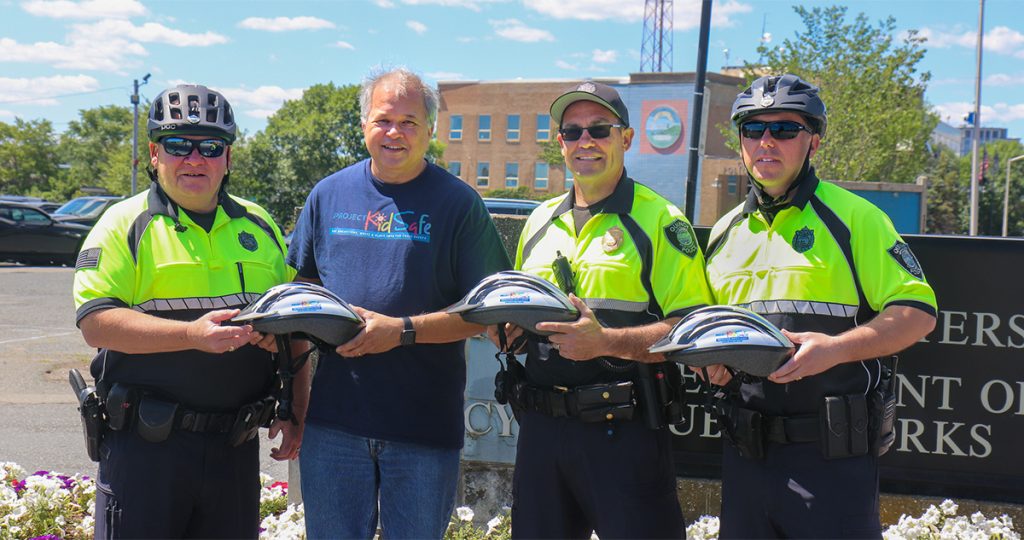 Quincy Police receive children's bike helmet donation from Breakstone, White & Gluck, a Boston law firm.