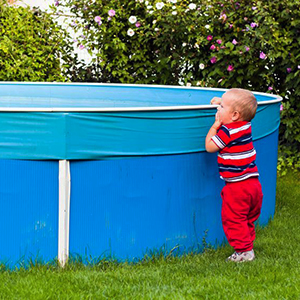 Young child at risk for falling and drowning in a backyard swimming pool.