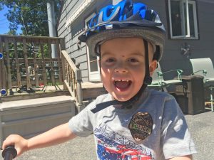Child riding a bicycle and wearing a bicycle helmet in Tewksbury, Massachusetts